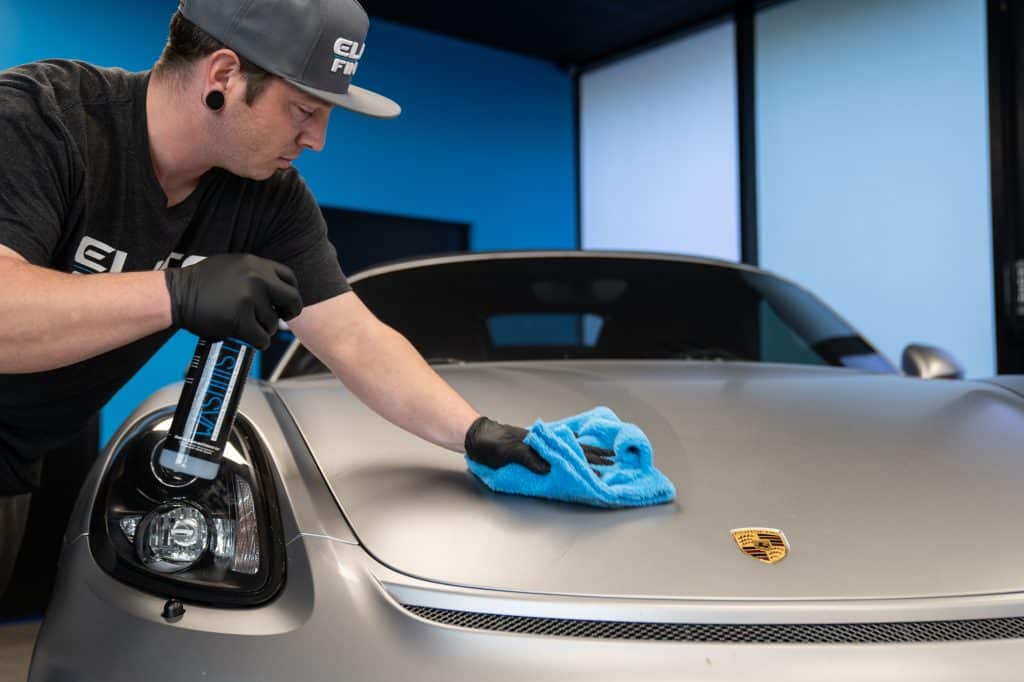 Elite Finish Detailer Spraying WashMist on a Porsche Spyder.